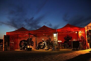 drei mobile 3x3m V2A-Messestände mit Werbung auf dem Volant